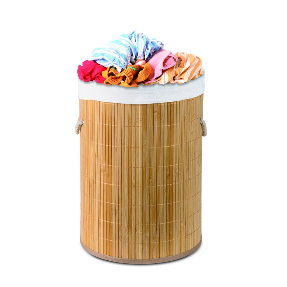 Round wooden laundry hamper with a colorful pile of clothes on top